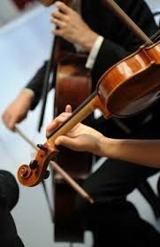 Close-up of musicians playing a violin and cello during a performance.